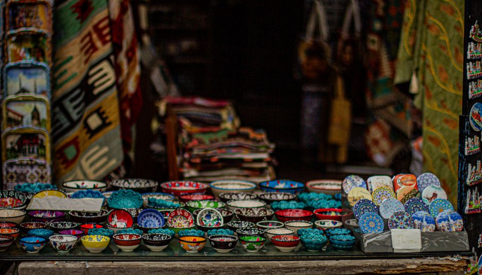 Colorful display of traditional Bolesławiec pottery mugs and dishes in a shop in Poland