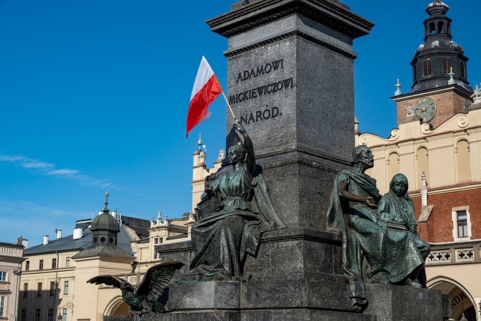 Tourists enjoying the vibrant atmosphere of Krakow's Main Market Square in Poland, symbolizing a worry-free travel experience with insurance.