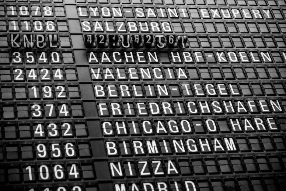 Departure board showing delayed flights at a Portuguese airport
