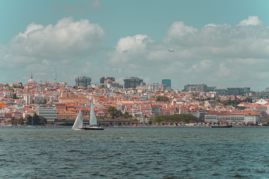Airplane landing at Lisbon Portela Airport in Portugal with city skyline in background