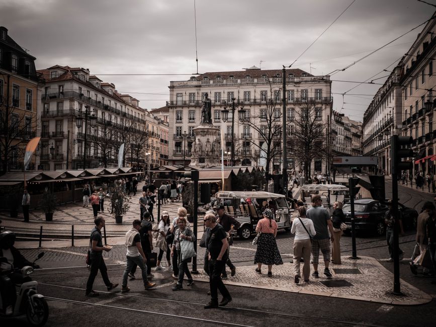 A bustling street in Lisbon, Portugal, with people enjoying the city safely
