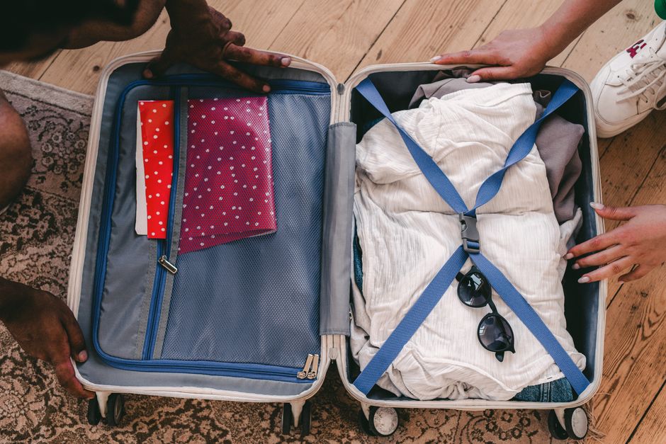 A thoughtfully packed suitcase ready for a trip to Romania, featuring clothes and travel essentials
