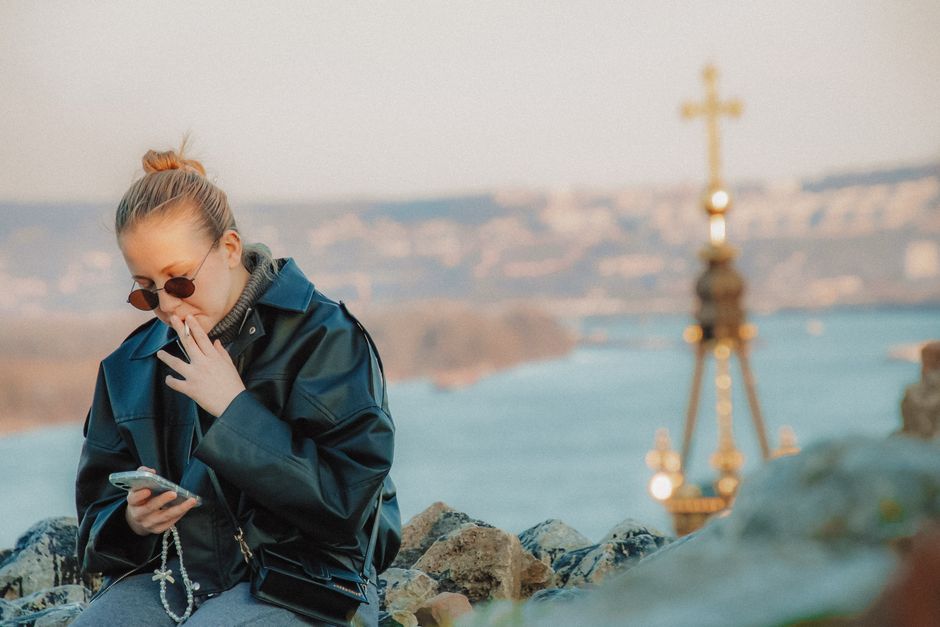 Traveler holding a smartphone in a bustling Belgrade street, connected to Serbia's mobile network