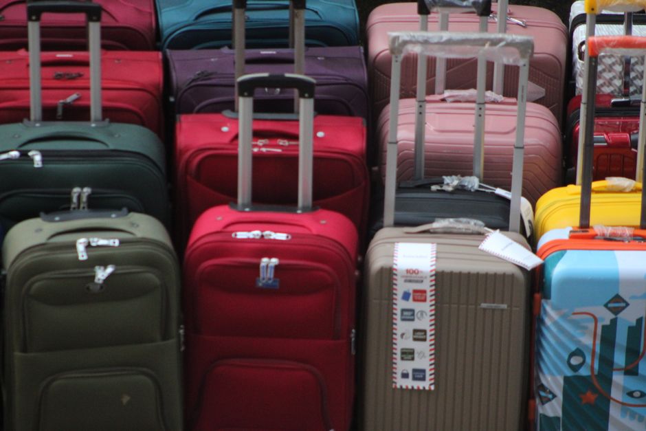 Traveler packing a suitcase with clothes and essentials for a trip to Serbia