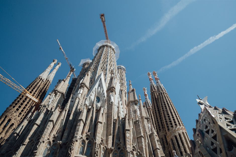 A guided tour group admiring the exterior of Sagrada Familia in Barcelona, Spain