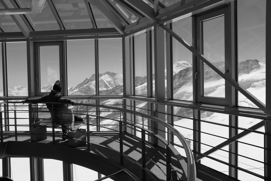 Traveler using smartphone with stunning Swiss Alps view, highlighting connectivity in Switzerland.