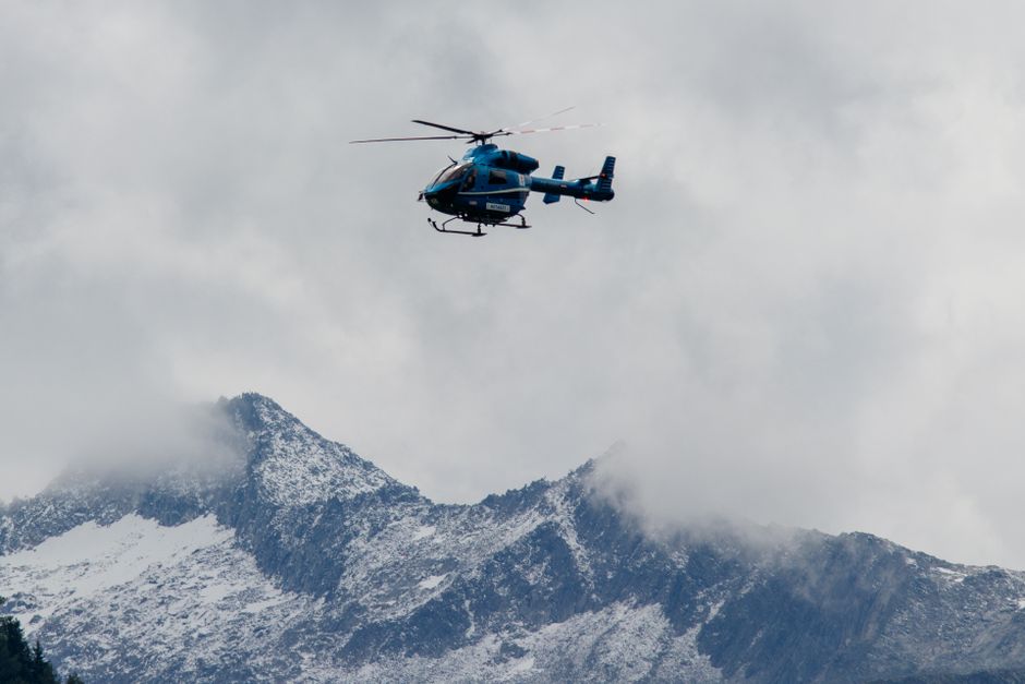 Swiss mountain rescue helicopter flying over the majestic Alps, symbolizing safety and emergency services in Switzerland