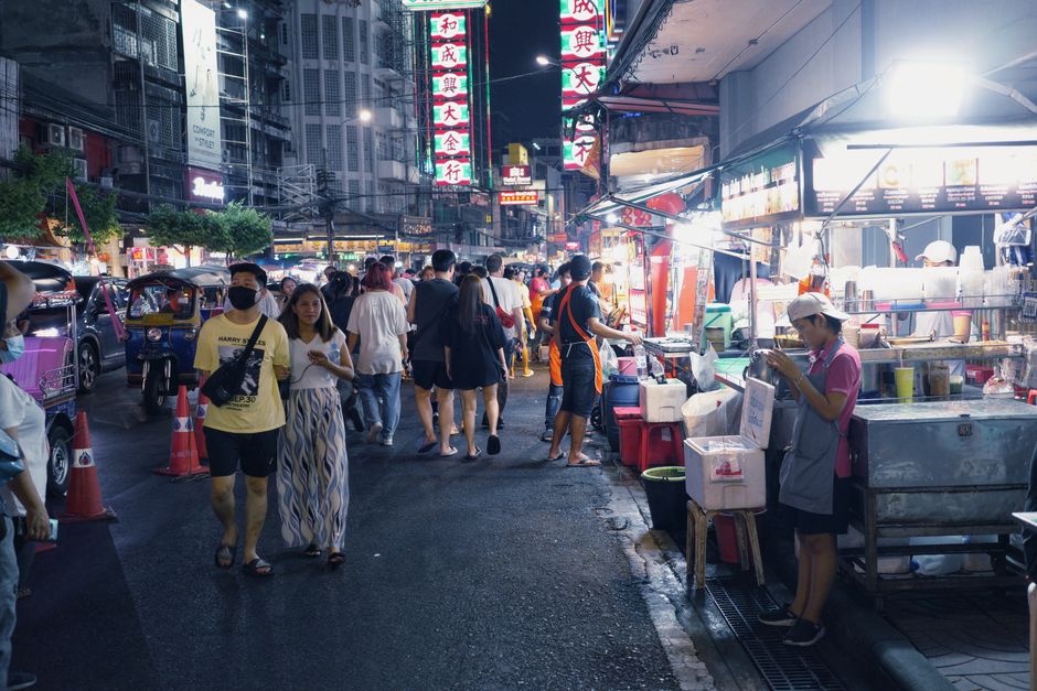 Vibrant street market scene in Thailand with food stalls and people