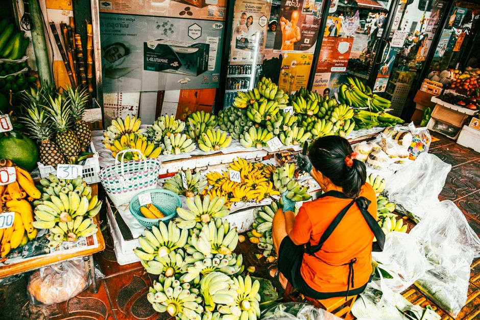 Vibrant street food market in Bangkok, Thailand, with various dishes and bustling activity