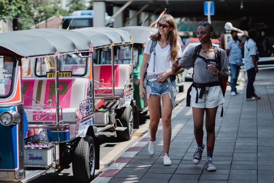 Tourist couple looking at a map in a safe, bustling street in Thailand