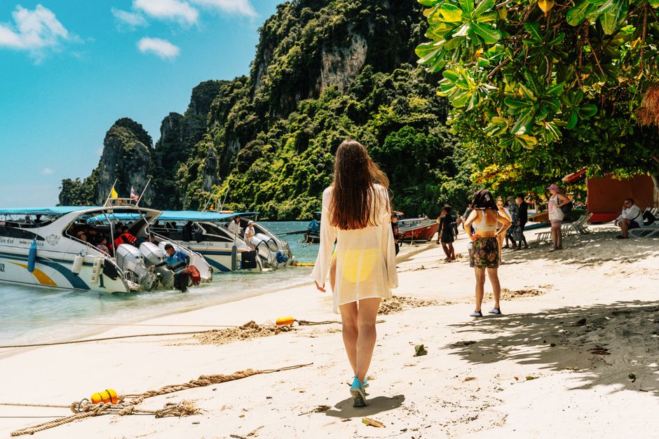 Traveler reviewing a travel insurance policy on a beautiful beach in Thailand