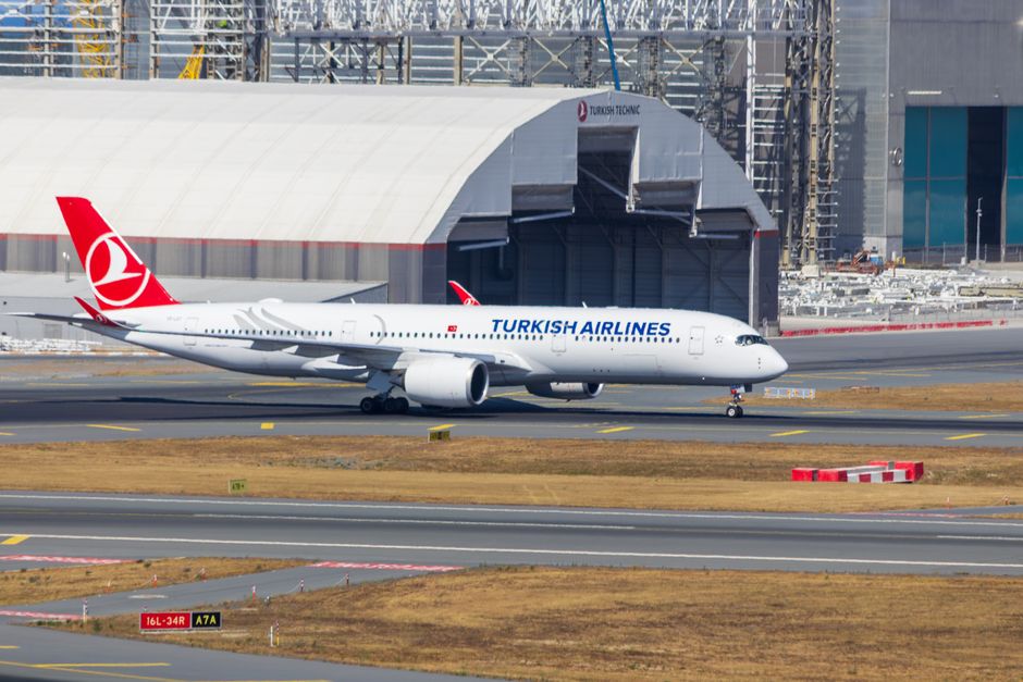 Turkish Airlines plane at Istanbul Airport terminal with a view of the city in Turkey