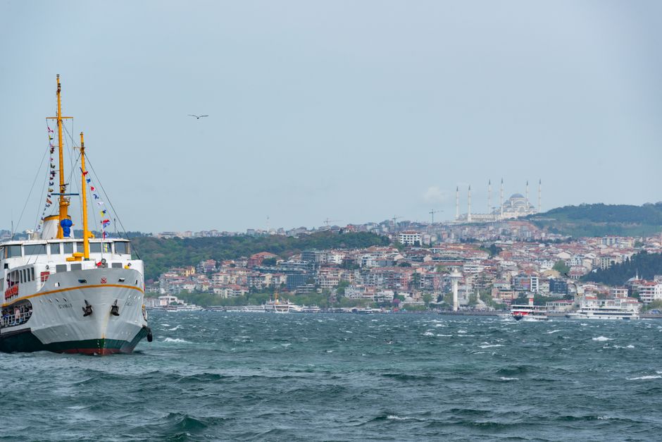 Traveler using a map app on a phone with Istanbul's Bosphorus in the background, Turkey