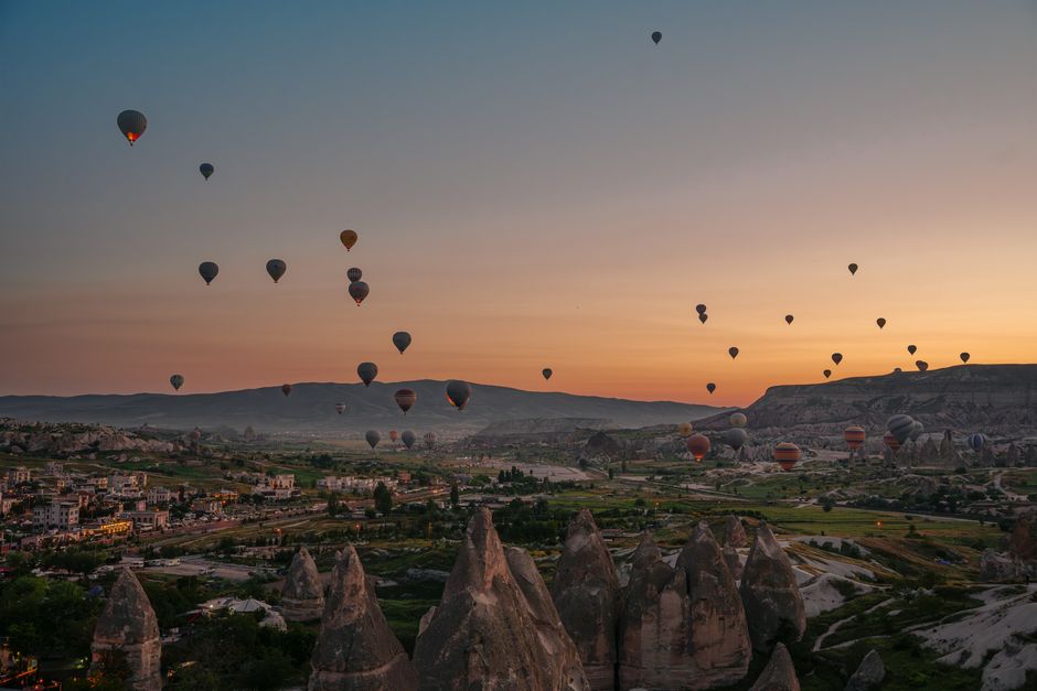 Hot air balloons floating over Cappadocia's fairy chimneys at sunrise in Turkey
