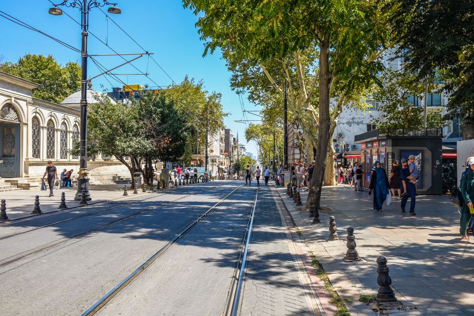 A traveler walking safely through a bustling street in Istanbul, Turkey, with historical buildings in the background.