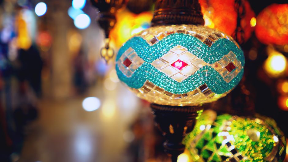 A bustling scene inside Istanbul's Grand Bazaar, showcasing colorful stalls and shoppers in Turkey