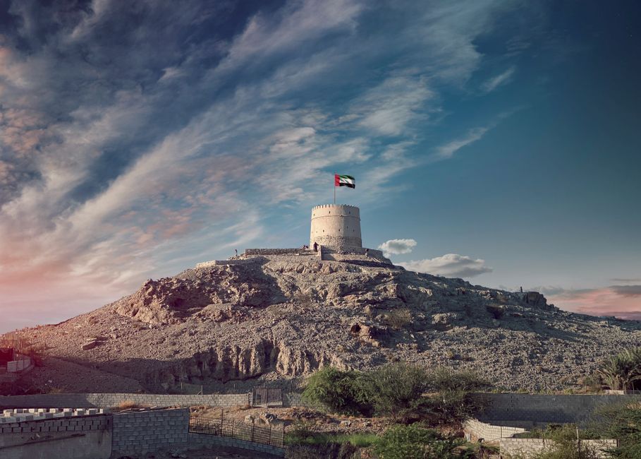Panoramic view of diverse UAE landscapes, including desert dunes, mountains, and a modern city skyline.