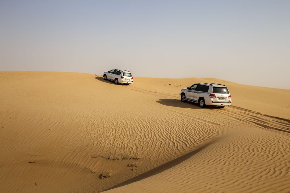 Tourists enjoying dune bashing on a desert safari in Dubai, UAE