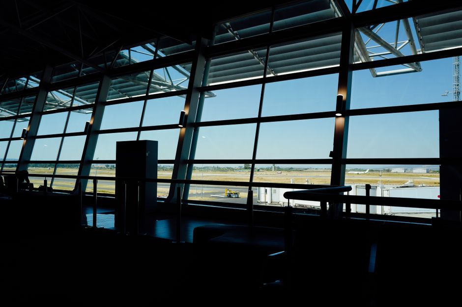 Bright, modern interior of a bustling airport terminal in the USA with travelers and shops