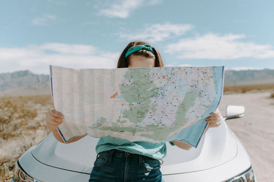Traveler planning a budget trip across the USA with a map and notes