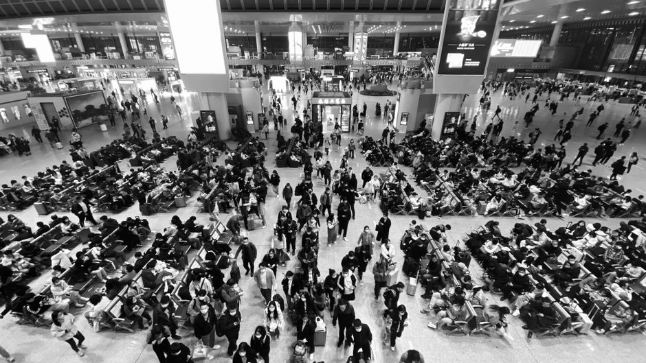 A traveler looking frustrated at an airport in the USA, possibly due to a flight delay or cancellation.