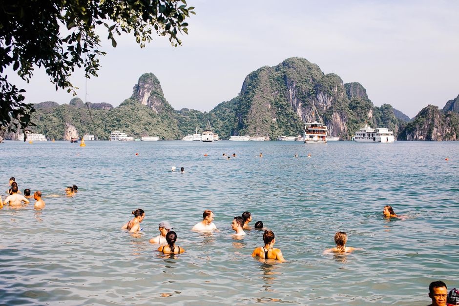 Traditional junk boats cruising through the magnificent limestone karsts of Ha Long Bay, Vietnam