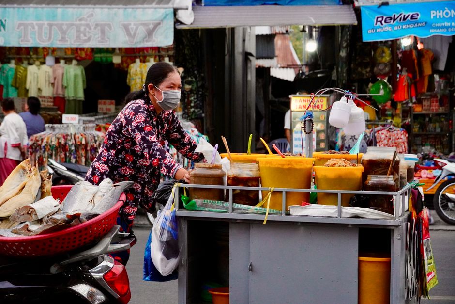 A bustling street food market in Hanoi, Vietnam, with various local dishes on display