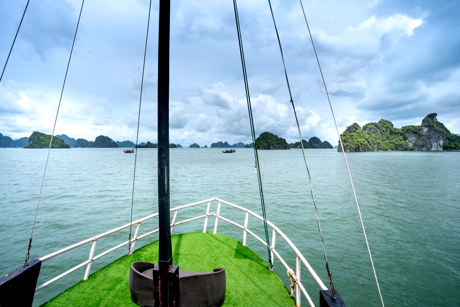 Traditional boat cruising through the limestone karsts of Ha Long Bay, Vietnam on a day trip