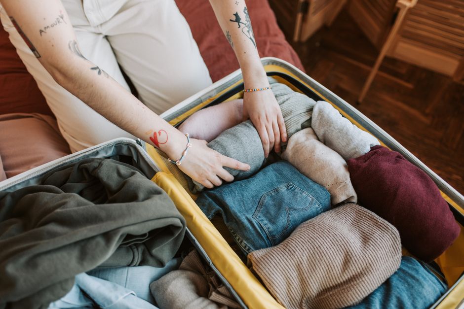 Traveler packing a suitcase with clothes and travel essentials for a trip to Vietnam