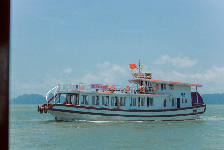 Traditional junk boat cruising through the limestone karsts of Ha Long Bay, Vietnam