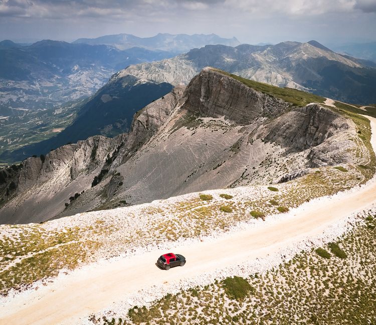 Car driving on a scenic mountain road in Albania with stunning views