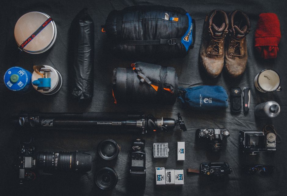 Flat lay of essential items for an Albania trip including sunscreen, map, and comfortable shoes