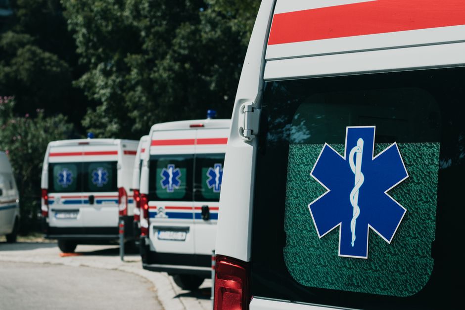Albanian emergency services vehicle with blue lights on a city street in Tirana