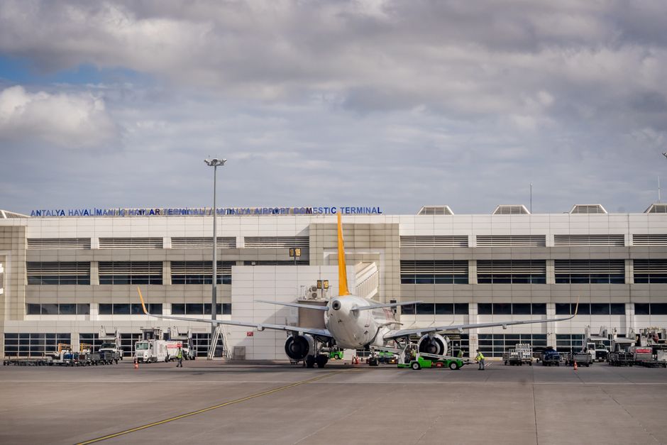 Exterior view of Zvartnots International Airport in Yerevan, Armenia, with cars and taxis.