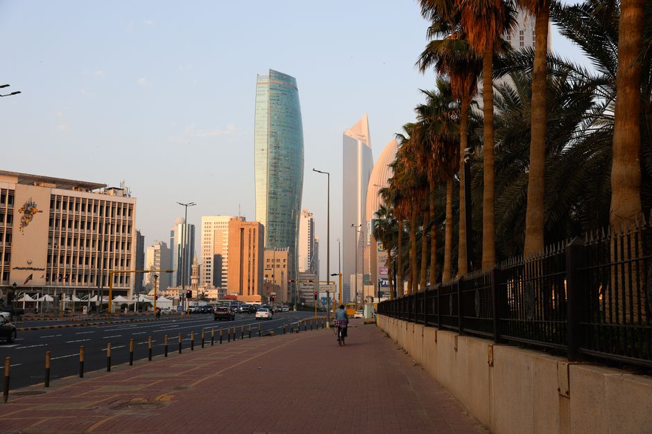 Modern cityscape of Manama, Bahrain with cars on a highway at sunset