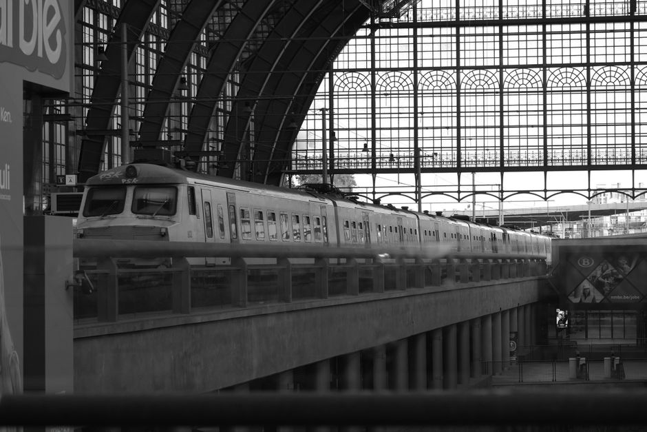 Modern train arriving at a bustling station platform in Belgium