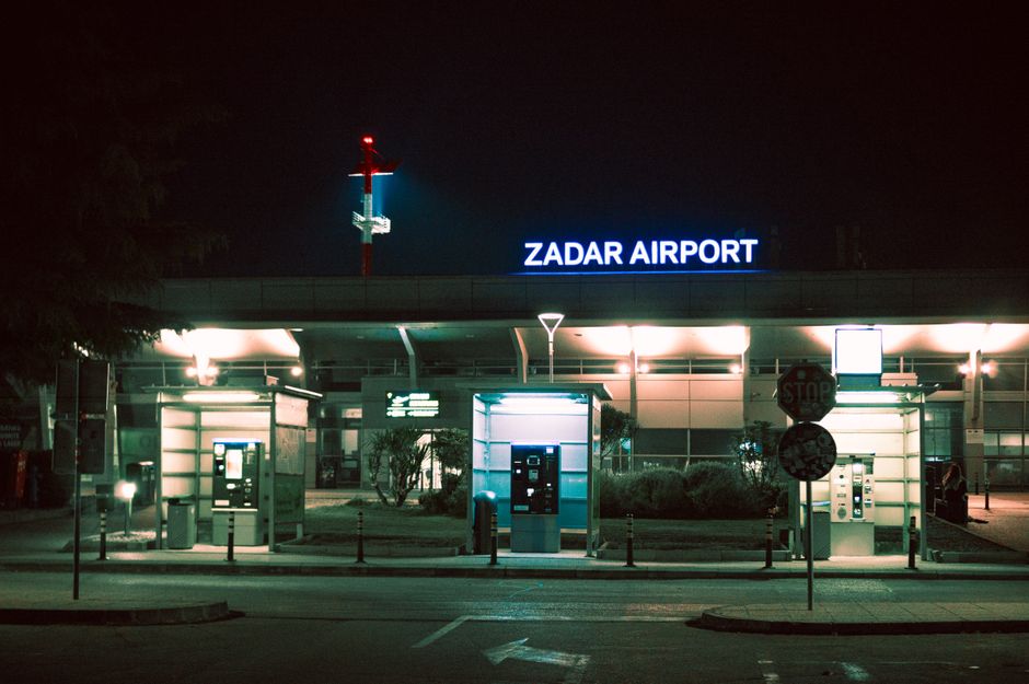 Exterior view of Sarajevo International Airport in Bosnia and Herzegovina with planes and mountains in the background