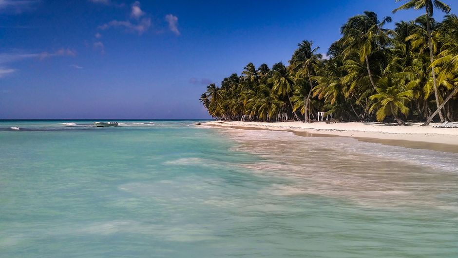 Airplane landing over a beautiful beach in the Dominican Republic with palm trees