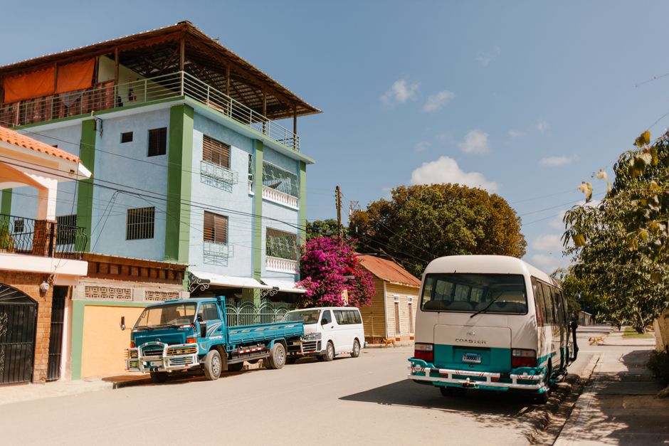 A colorful Caribe Tours bus at a bustling terminal in Santo Domingo, Dominican Republic, ready for regional travel.