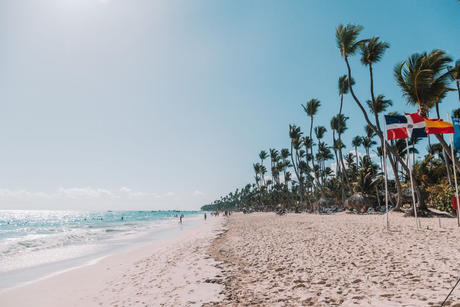 Tourist happily using a smartphone on a beautiful beach in the Dominican Republic