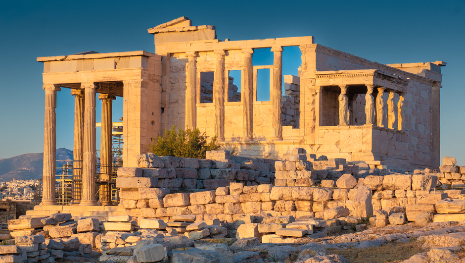 Panoramic view of Athens, Greece with the illuminated Acropolis at sunset, symbolizing travel and exploration.