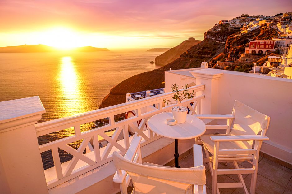 Iconic white-washed villages overlooking the caldera in Santorini, Greece at sunset