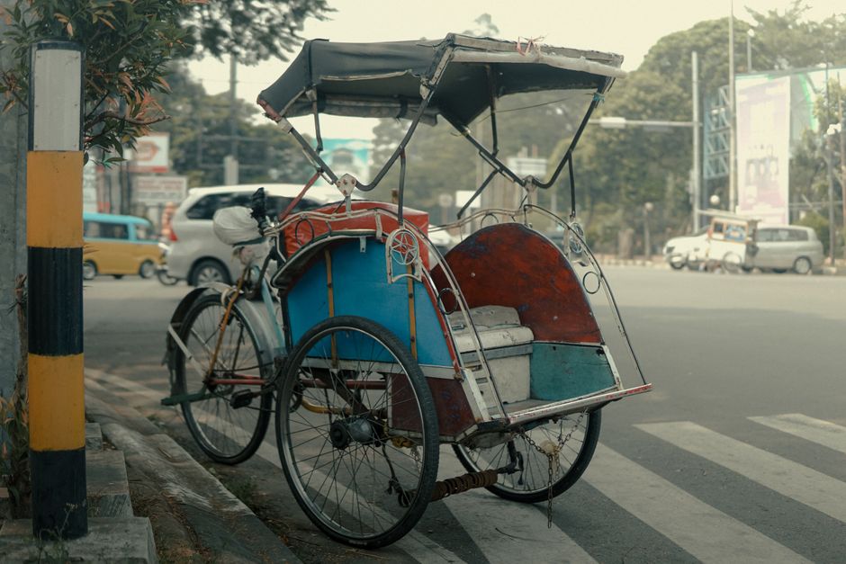A bustling street scene in Indonesia showcasing various modes of transport like scooters and cars