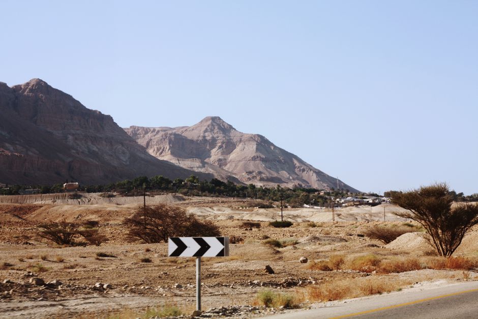 Compact rental car driving on a scenic road in Israel with mountains in the background