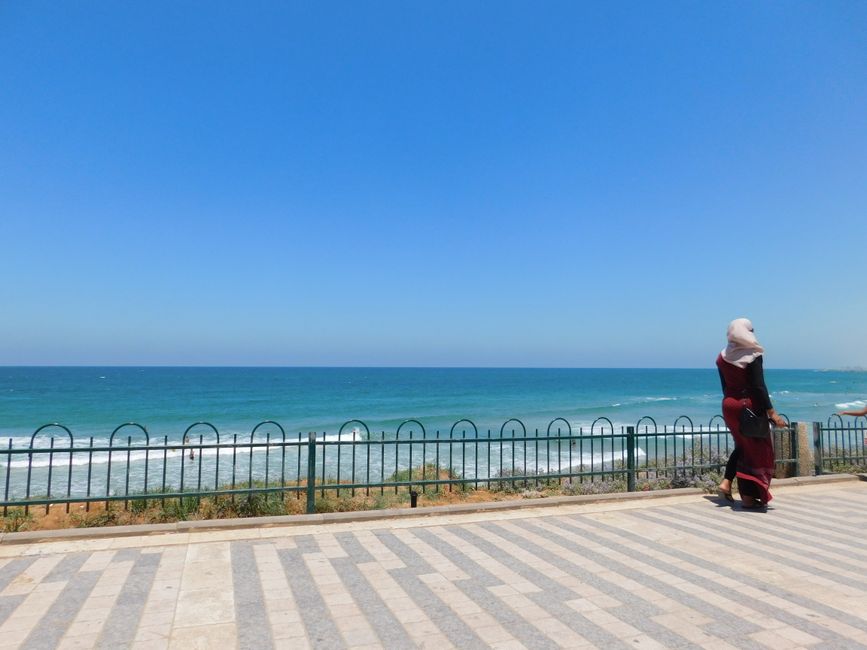 Traveler using a smartphone for navigation in a bustling Tel Aviv street, Israel