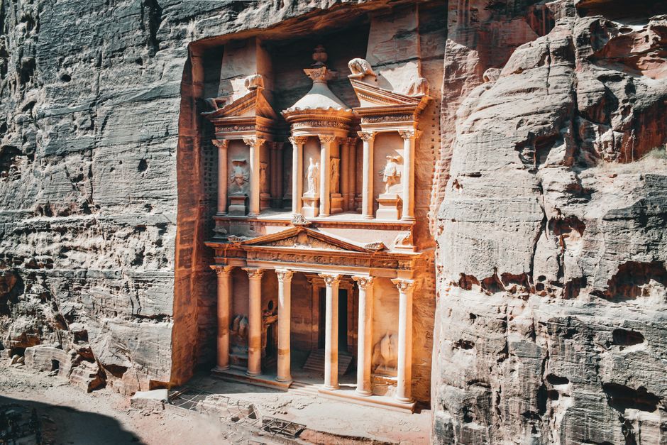A traveler holding a Jordan Pass with the iconic Petra Treasury in the background, Jordan