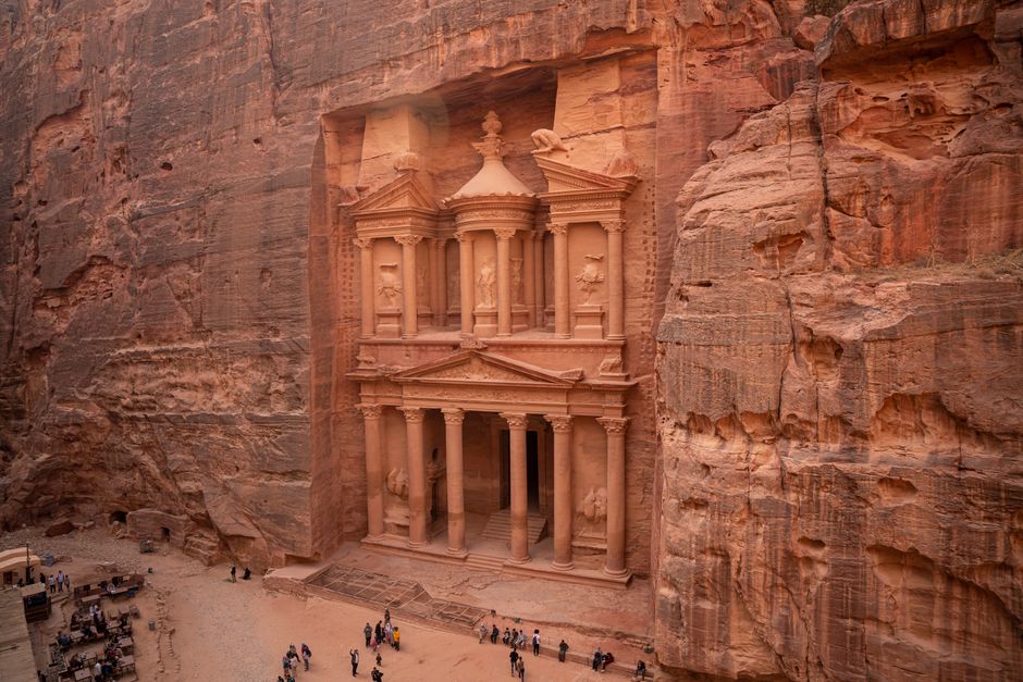 Traveler using a smartphone with a Jordan SIM card in front of the Treasury at Petra, Jordan