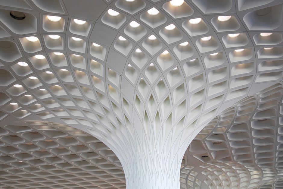 Modern exterior of Kuwait International Airport (KWI) terminal building under a clear sky