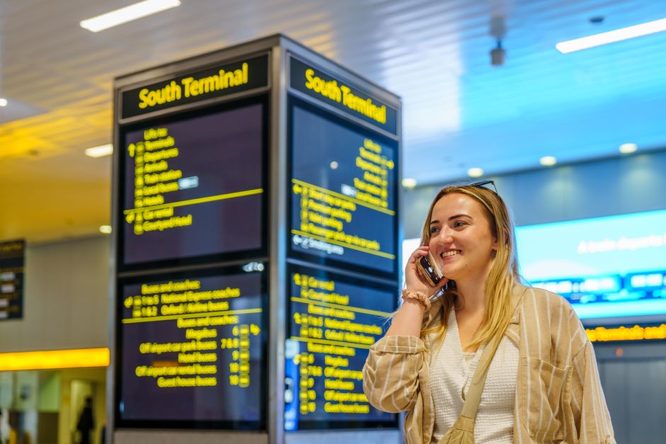 Departure board showing delayed flights at Kuwait International Airport