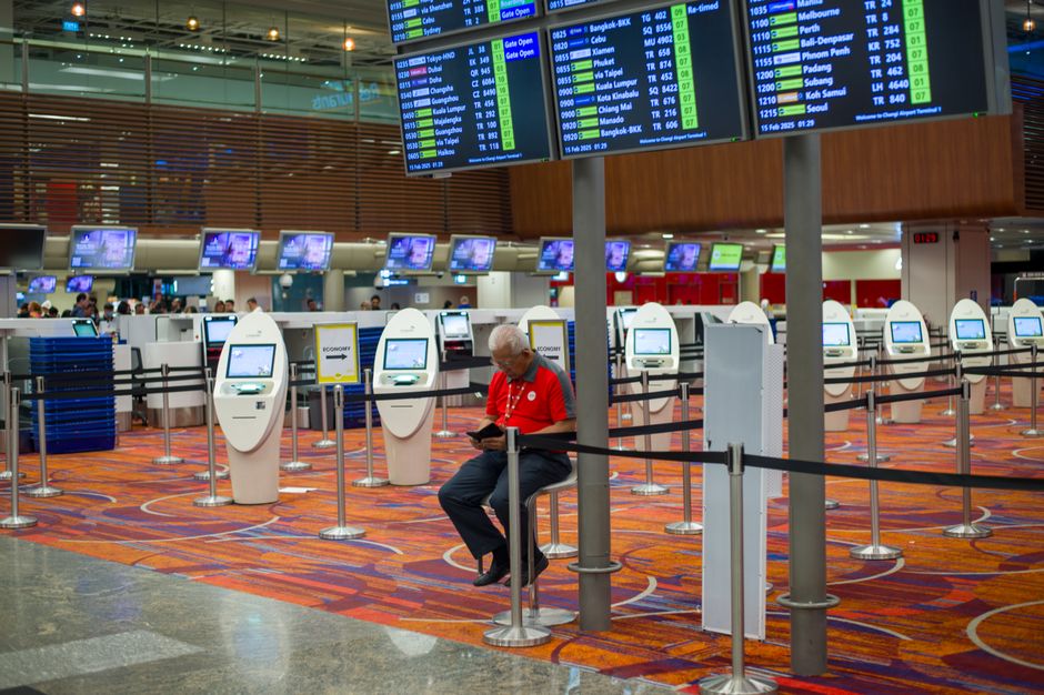Travelers purchasing SIM cards at a telecom kiosk in Kuwait International Airport
